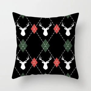 Close-up of Christmas pillow cover with white reindeer and festive plaid pattern