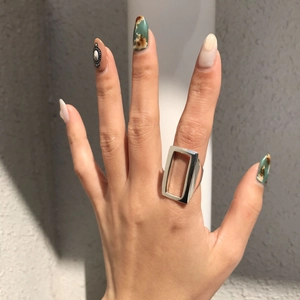 Detail of a geometric hollow rectangular 925 silver ring worn on index finger