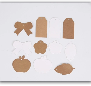 Flat lay of vintage kraft and white paper gift tags in butterfly, flower and leaf shapes