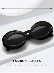 Detail of vintage oval thick-frame black sunglasses on white geometric pedestal