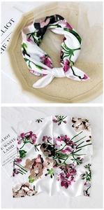 Close-up of floral print silk scarf with fine edge stitching and smooth texture detail