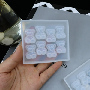 Detail of hand holding flexible 8-cavity bear silicone mold for DIY resin and plaster