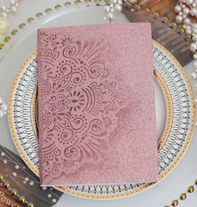Macro detail of rose gold glitter laser cut lace floral pattern wedding invitation card
