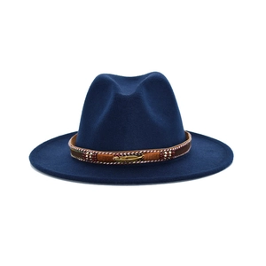Detailed view of navy blue wool fedora featuring a brown band with a golden feather charm