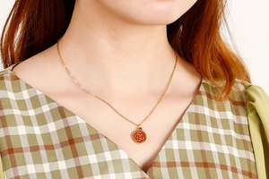Golden necklace with red rose pendant showcased on a model's neck for elegant wear