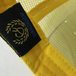 Gros plan sur l'étiquette tissée et le tissu en maille d'une casquette trucker jaune