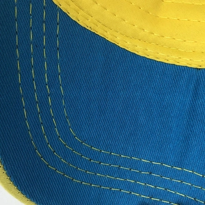 Détail du bord de casquette en sergé bleu avec coutures de renfort jaunes contrastées