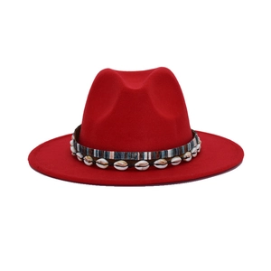 Detail of red fedora hat featuring bohemian ribbon and natural shell decorations