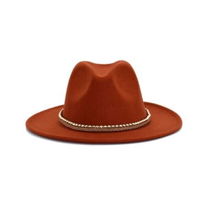 Λεπτομέρεια καραμελέ τσόχινου καπέλου fedora με χρυσή αλυσίδα και υφαντή ταινία