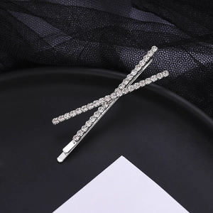 Elegant silver-toned criss-cross hair clip with shimmering rhinestones on a black background
