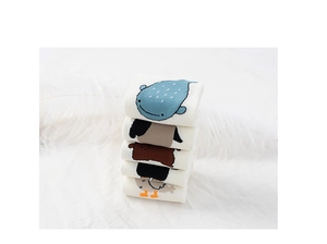 Close-up of five white cotton socks with cute cartoon animal patterns on soft feathers