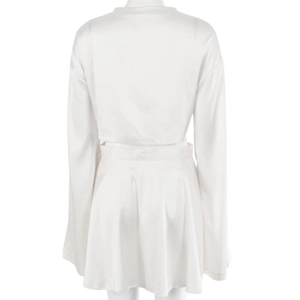 Détail d'un ensemble en satin blanc avec crop top manches longues et mini-jupe