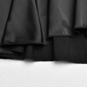 Détail macro du tissu en satin noir avec finition de couture d'ourlet roulé soignée