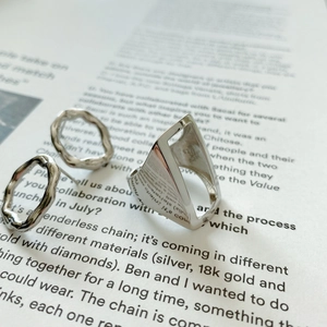 Macro shot of 925 sterling silver rectangular hollow ring and irregular earrings