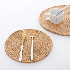 Set of two round woven jute placemats for dining table heat protection in natural brown