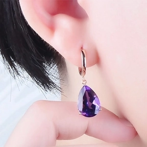 Rose gold amethyst drop earrings with pear-cut purple gemstones worn by model