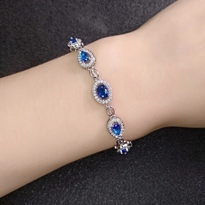 Elegant silver bracelet with teardrop blue gemstones and pavé crystals on wrist