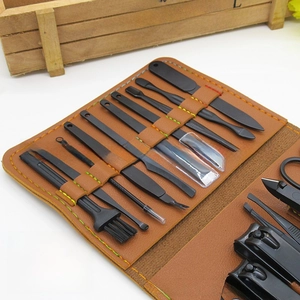 Close-up of 16-piece black matte manicure set in a brown leather case with green stitching