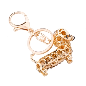 Close-up of a golden dachshund keychain with crystal-studded hollow-out design
