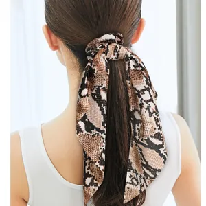 Long satin bow scrunchie with brown python snake print on woman's ponytail back view