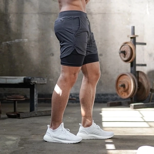 Detail of dark grey 2-in-1 men's sports shorts with inner layer and side zipper pocket