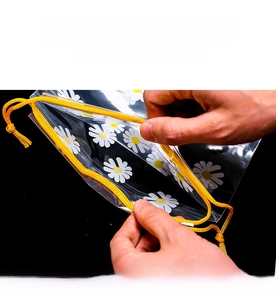 Detail of daisy pattern and yellow drawstring closure on frosted plastic storage bag