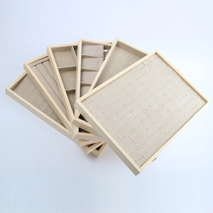 Minimalist wooden jewelry display trays with beige linen lining in a fan-shaped arrangement