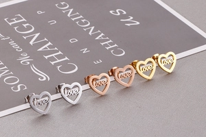 Detailed view of hollow heart earrings with LOVE engraving in silver, gold, and rose gold