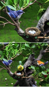 Detailed view of colorful resin birds and artificial nest with speckled blue eggs