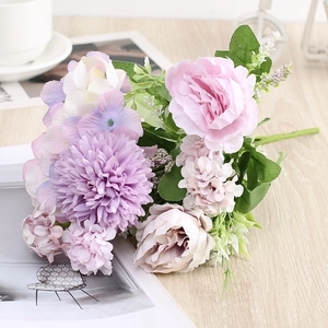 Elegant artificial silk flower bouquet with pink roses and purple hydrangeas on wood