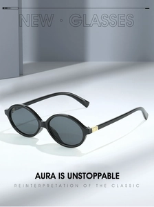 Detail shot of black oval sunglasses featuring a stylish golden square metal hinge accent