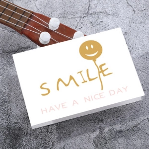 Detailed view of white card with gold smile balloon and HAVE A NICE DAY text