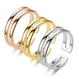 Close-up of three polished double-row open rings in rose gold, gold, and silver finishes
