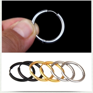 Detailed close-up showing silver, gold, and black stainless steel hoop earrings for men