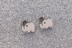 Macro view of elephant stud earrings in polished silver steel with crystal eyes
