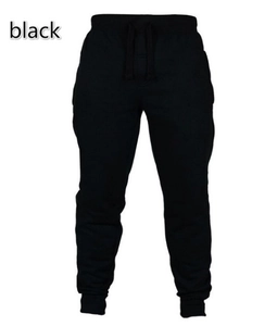 Close-up of black joggers with drawstring waist and ribbed ankle cuffs on white background