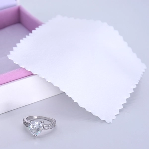 Silver heart ring with pavé diamonds displayed with jewelry box and cleaning cloth