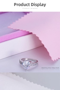 Detailed view of a silver heart-shaped diamond ring with a pink cleaning cloth