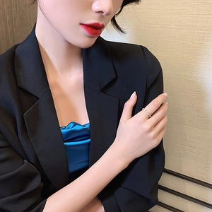 Minimalist gold ring with sparkling circular crystals shown on model in stylish attire