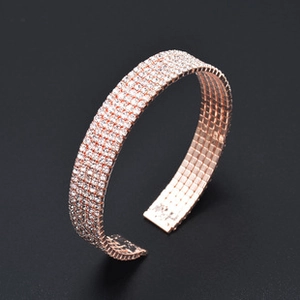 Detailed close-up of rose gold cuff bracelet paved with multiple rows of sparkling crystals