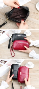 Pochette à trois zips en cuir grainé montrant l'intérieur et la dragonne amovible