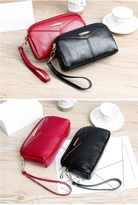 Pochettes en cuir à texture litchi rouge et noir avec dragonnes sur table en bois