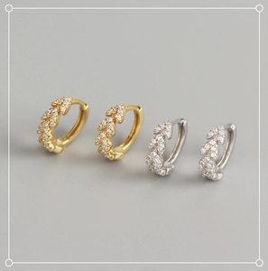 Détail de boucles d'oreilles feuilles en argent S925 doré et argenté avec zircons