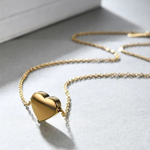 Minimalist 18K gold plated stainless steel heart pendant necklace on textured background