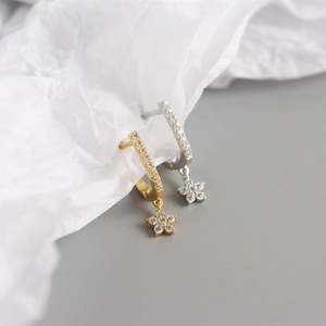 Detailed view of U-shaped sterling silver hoop earrings with diamond flower charms