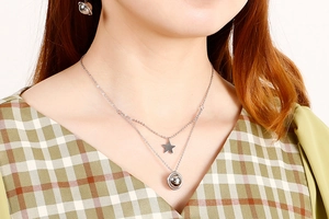 Close-up of double layer star and planet pendant necklace with matching earrings set