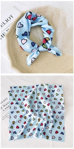 Macro detail of sky blue silk scarf with colorful heart patterns and smooth texture
