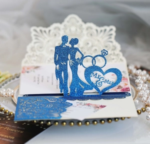Detail view of 3D wedding card with glittering blue Mr & Mrs silhouettes and hollow design
