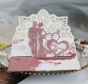 Detail of rose gold laser cut wedding invitation with Mr. & Mrs. silhouette and pearls