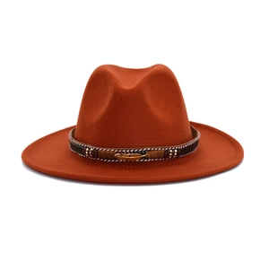 Detail of caramel fedora hat featuring woven band with golden feather and beaded accents